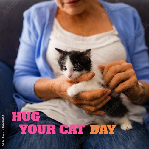Composite of hug your cat day text with caucasian senior woman sitting with kitten, copy space