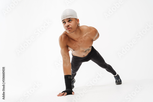 Young shirtless sportsman doing exercise while working out