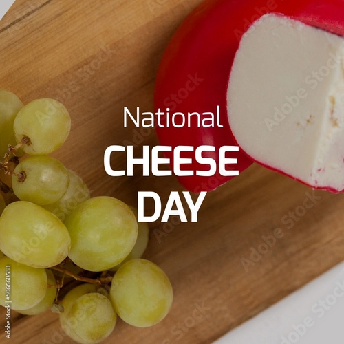 Composite of national cheese day text with cheese by grapes on wooden board, copy space