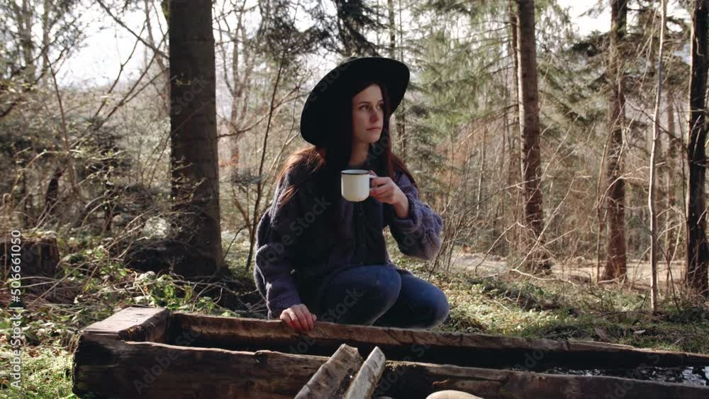 girl in the forest and picks up a mug of spring water outdoors and drinks girl in the forest and picks up a mug of spring water outdoors and drinks