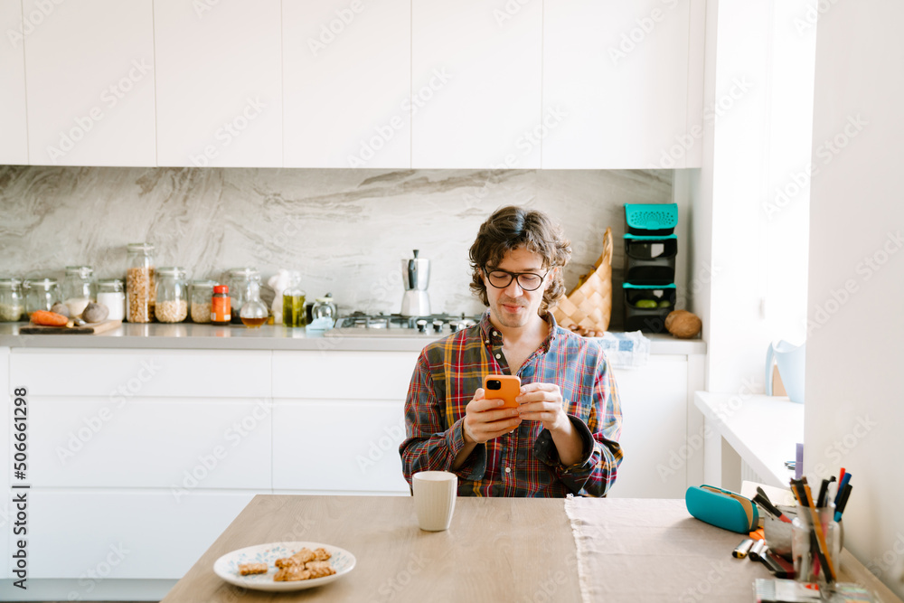 White man using mobile phone while having breakfast White man using mobile phone while having breakfast