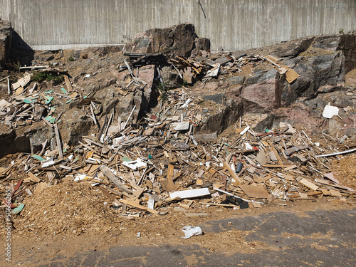 a stone wall in a garbage dump. wooden waste in a landfill. High quality photo