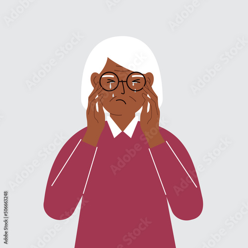 Upset grandmother cries and holds his head with his hands. The concept of resentment, pain and depression.