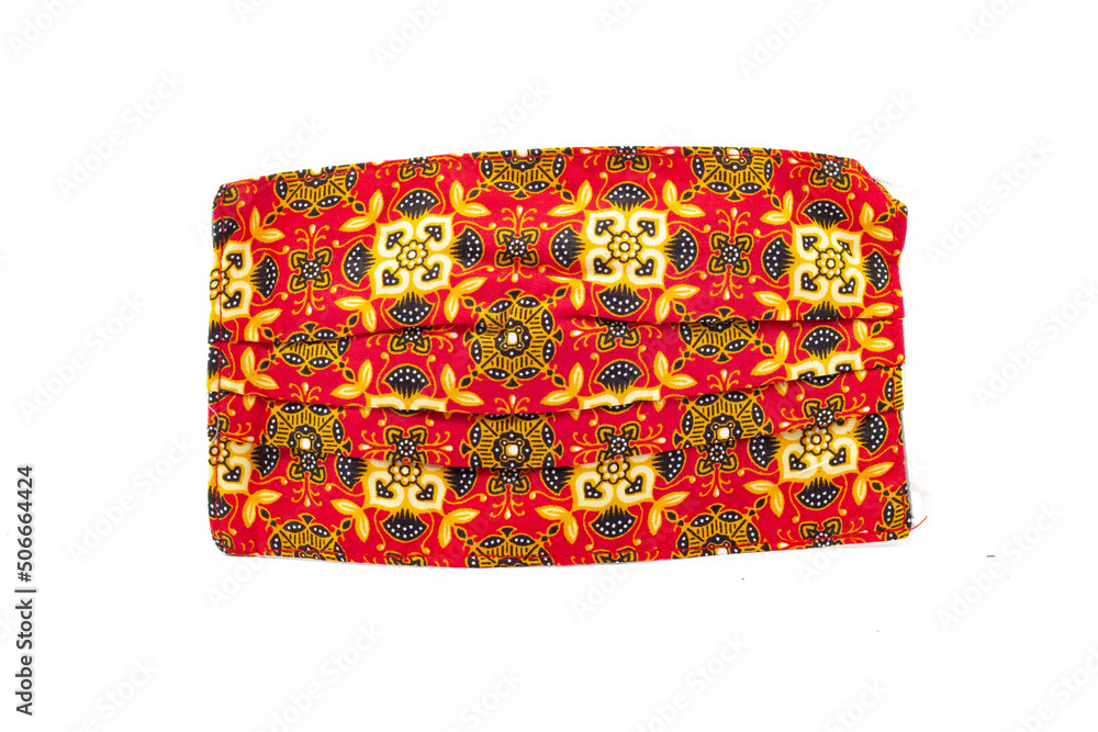 mask of batik motif on an isolated white background. orange color. copy space of health, guards, fashion and clothing accessories. mask of batik motif on an isolated white background. orange color. copy space of health, guards, fashion and clothing accessories.