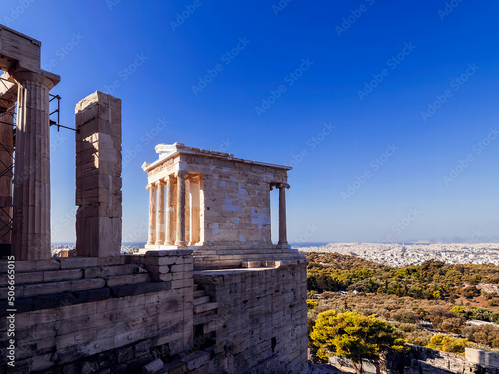 The Athena Nike ancient Ionian order temple, overlooking the south part of Athens, Greece. It is a four column Ionic structure with a colonnaded portico at both front and rear facades.