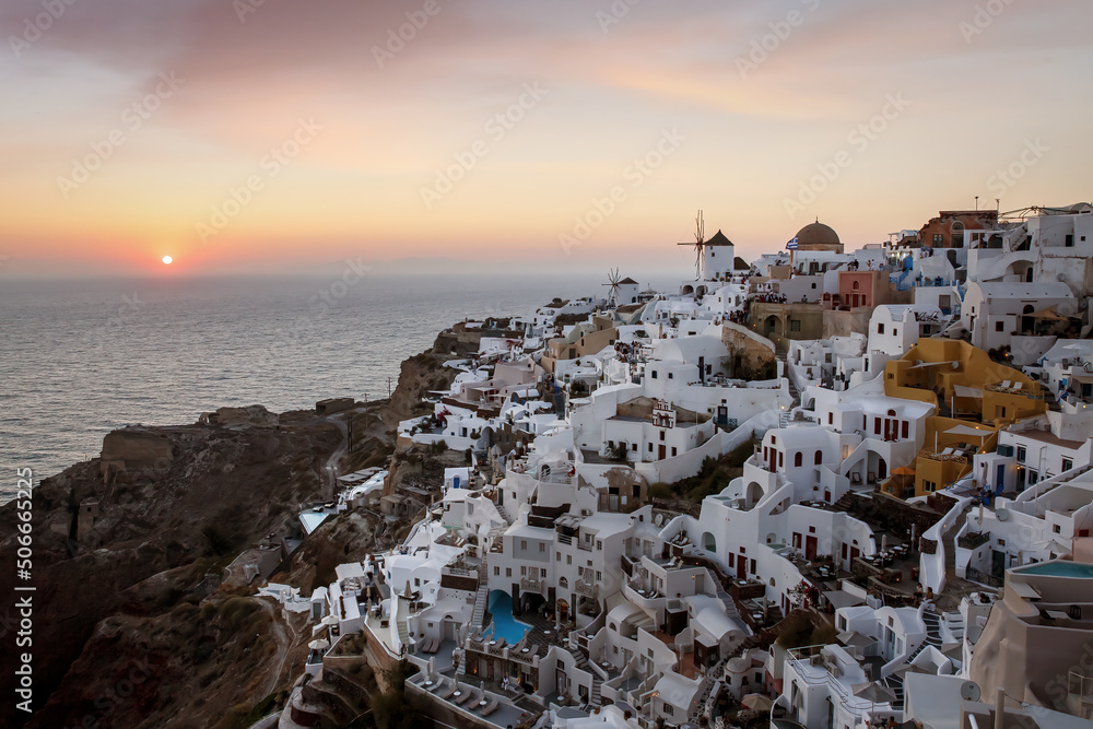 Santorini view. Oia village on sunset. White buildings architecture during twilight.