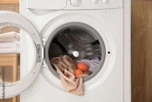 Dryer balls and clothes in washing machine, closeup