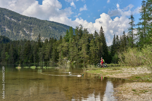 nice senior woman riding her electric mountain bike iat lake Weissensee near Fern Pass in Tirol, Austria photo