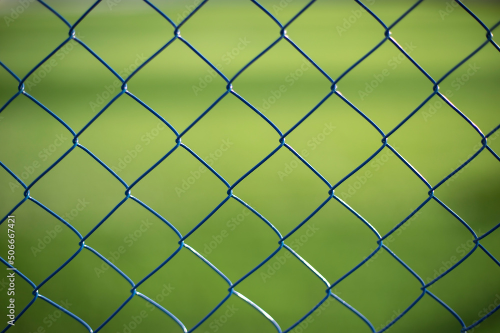 Fototapeta premium Mesh fence on vernacular background. Fence details.