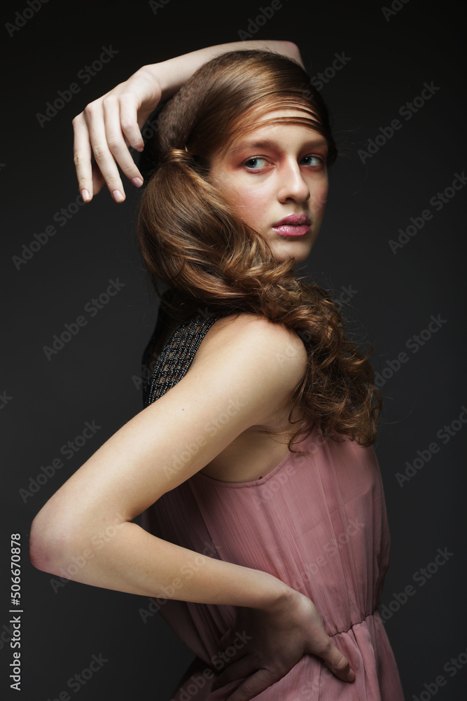 Beautiful woman with make up in pink tones. Young female model with braided braid over black background. Beautiful woman with make up in pink tones. Young female model with braided braid over black background.
