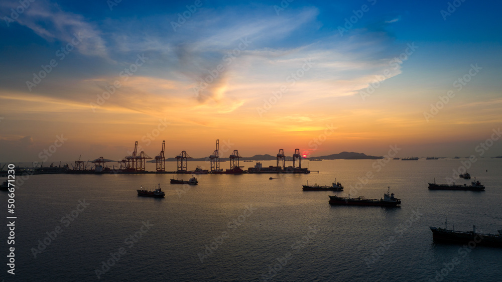 crane loading cargo container to container maritime ship in the international terminal container depot yard port concept freight shipping by ship at sunrise