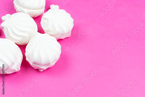 Airy white marshmallows on a bright pink background. Space for text. Recipe for cooking.