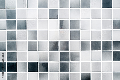 White and grey small ceramic tiles on a bathroom wall, modern clean tile as texture or background