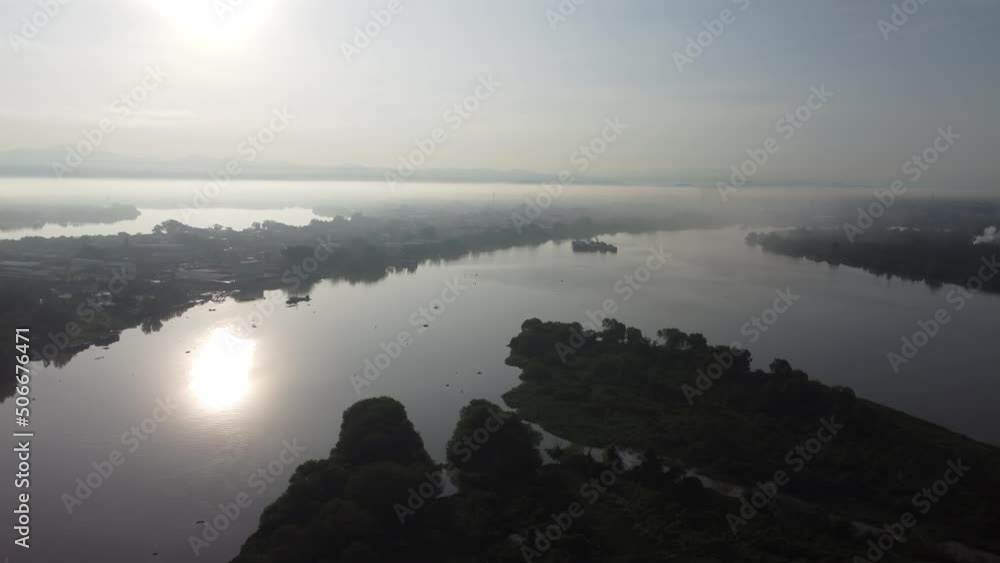 Fly over small island at Pulau Bangau river in misty morning Fly over small island at Pulau Bangau river in misty morning