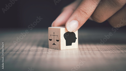 Ethics inside human mind, Business ethics concept. Hand flip ethics inside a head symbols in wooden cubes on dark background with copy space. photo