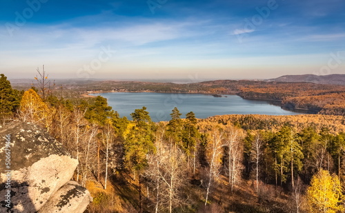 Autumn landscape from the top of a mountain with a lake  trees  mountains and sky
