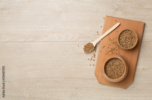 Wholegrain spelt farro in bowl on wooden background. Top view photo