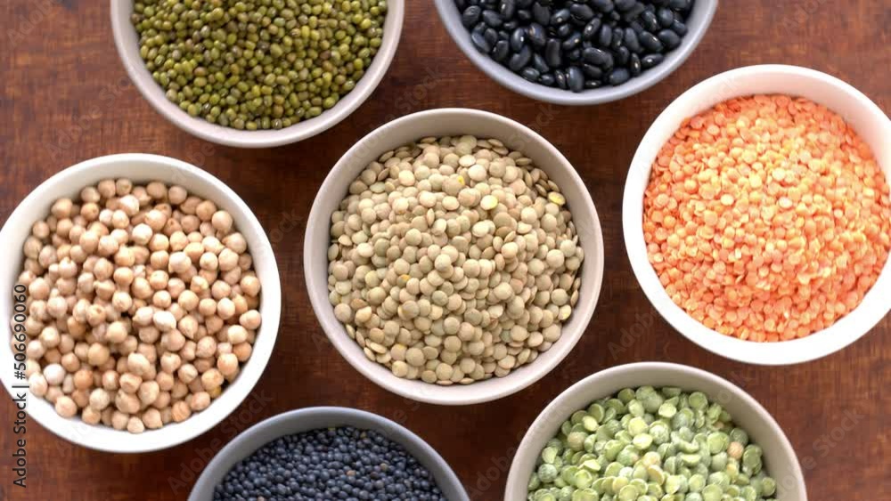 Assortment of dry beans and lentils in bowls. Table spin, top view. Assortment of dry beans and lentils in bowls. Table spin, top view.