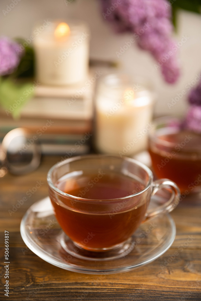 A cup of green tea against the background of a spring bouquet of lilacs . Romantic composition with books and candles. spring tea drink. Place to copy. Romantic concept. A cup of green tea against the background of a spring bouquet of lilacs . Romantic composition with books and candles. spring tea drink. Place to copy. Romantic concept.