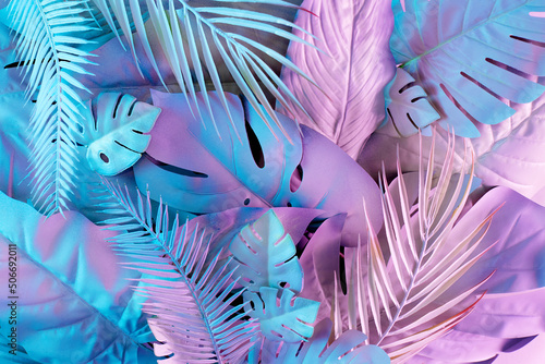Creative jungle neon color layout made of tropical leaves. Flat lay fluorescent colors. Nature concept.