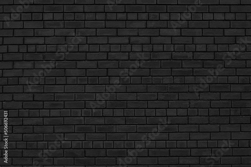 Old shabby black brick wall texture. Rough brickwork dark gloomy wallpaper. Abstract grunge textured background