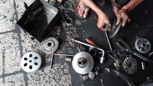the mechanic's hand is cleaning the automatic motor CVT components manually during routine service. 