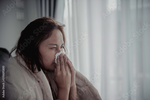 Asian sick woman sit on the sofa stay at home,The woman felt bad, wanted to lie down and rest,high fever