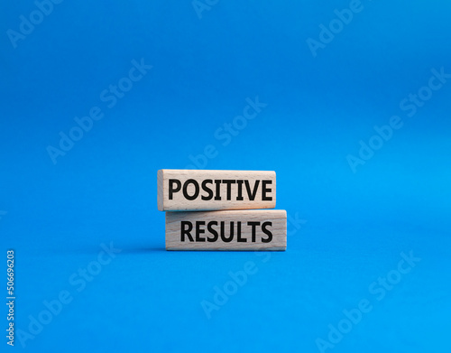 Positive results symbol. Concept words 'Positive results' on wooden blocks. Beautiful blue background. Business and Positive results concept. Copy space.