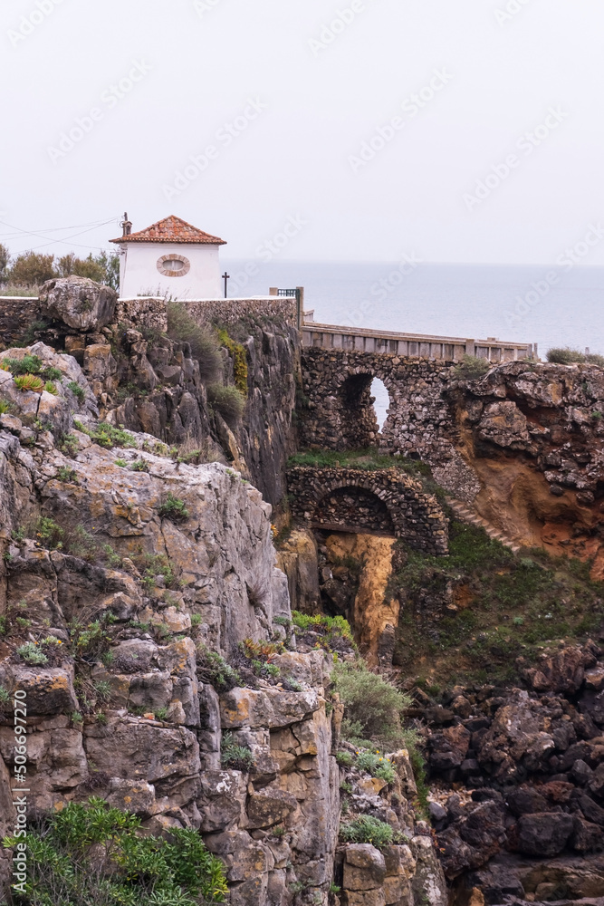 A small building on a cliff above the ocean next to Boca de Inferno