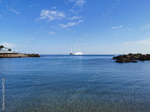 The largest sailing yacht in the world, an eight-deck motorsailer on the Mediterranean coast against a blue sky with beautiful clouds.