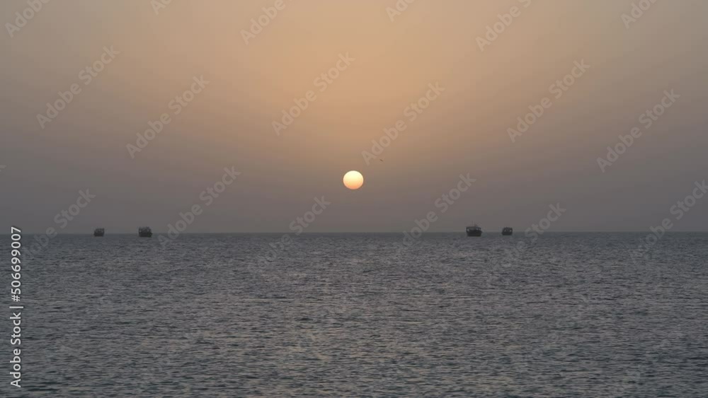 Sunset on the Indian Ocean in 4k video, with traditional Arabic Dhows (wooden boats of fishermen) and the sun at background, Masirah Island, Sultanate of Oman Sunset on the Indian Ocean in 4k video, with traditional Arabic Dhows (wooden boats of fishermen) and the sun at background, Masirah Island, Sultanate of Oman
