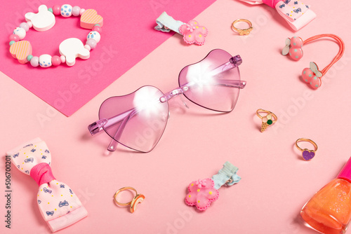 Baby accessories sunglasses and a hat on a pink background. Little girls accessories, flat lay