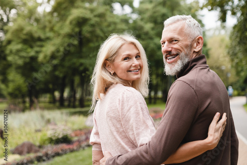 Smiling happy caucasian mature spouses hugging embracing while walking on a date in park together. Bonding, love and relationship © InsideCreativeHouse