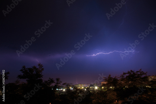Lightning discharges over the city. A summer thunderstorm at night.