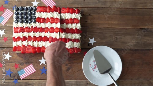 Cutting cake in the colors of the US flag. Independence Day celebration.
