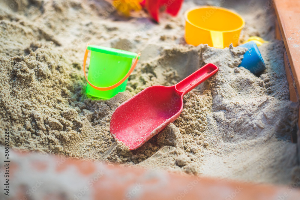Children plastic toys in the sand box. Shovel, selective focus. Children plastic toys in the sand box. Shovel, selective focus.