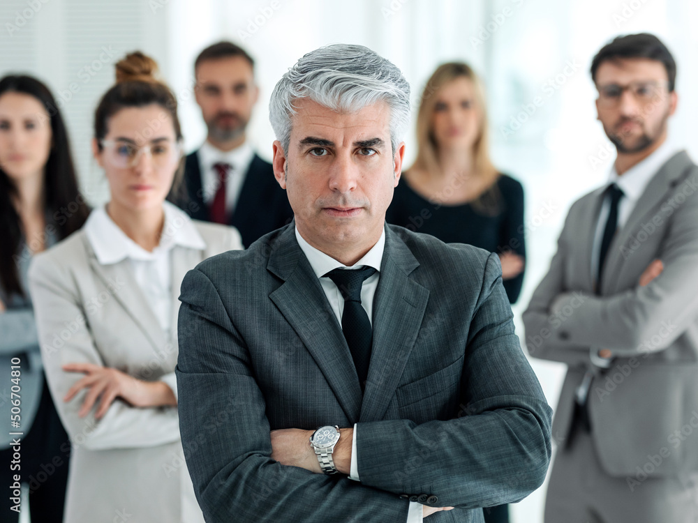 Successful business multiage team posing and looking at camera in modern startup. Successful business multiage team posing and looking at camera in modern startup.
