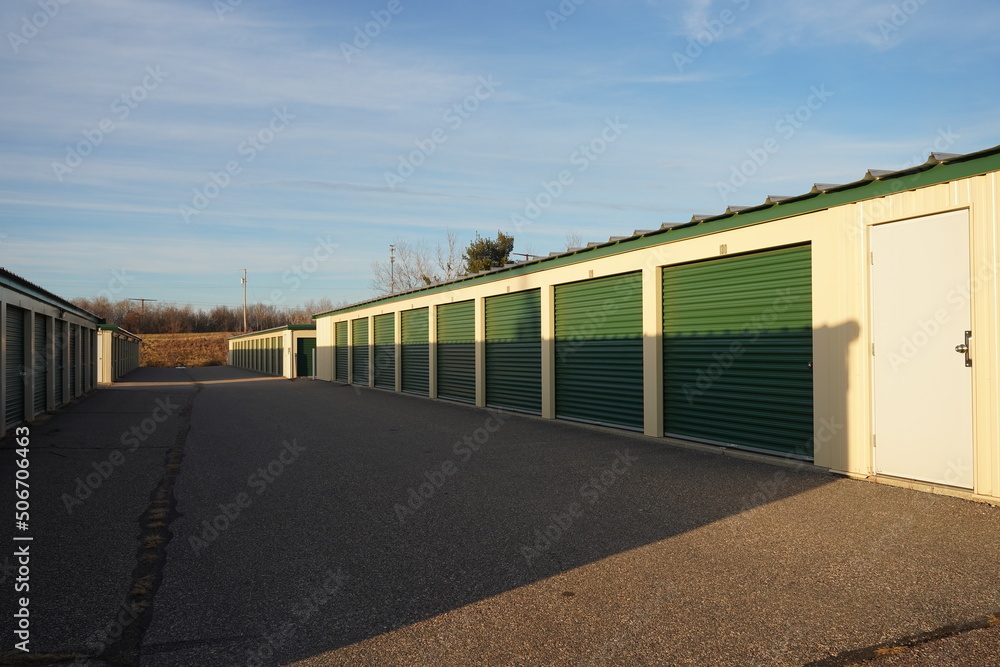 Green and tan storage units service the community to hold the owner's property. Green and tan storage units service the community to hold the owner's property.