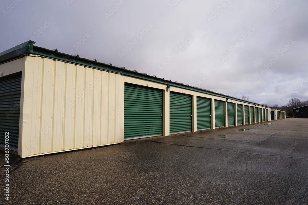 Green and tan storage units service the community to hold the owner's property. Green and tan storage units service the community to hold the owner's property.