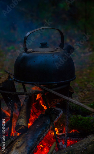 an old camping kettle is heated on a fire