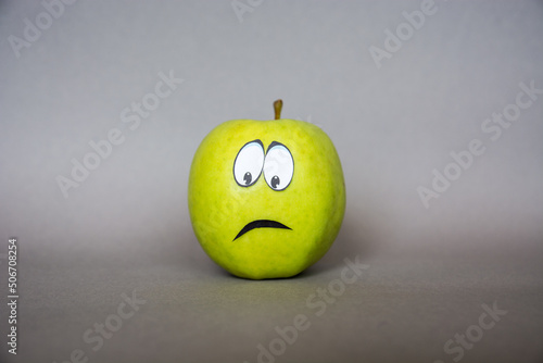 negative emotions from fear to panic,  sad Face on an apple - abstract image of human emotions on blue background	
 photo