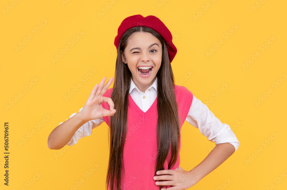 happy teen school girl in french beret show ok gesture on yellow background, perfection happy teen school girl in french beret show ok gesture on yellow background, perfection