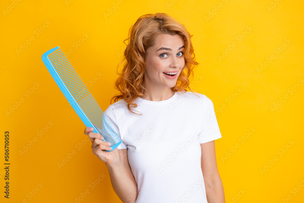 Redhead woman with a comb, isolated on yellow background. Redhead woman with a comb, isolated on yellow background.
