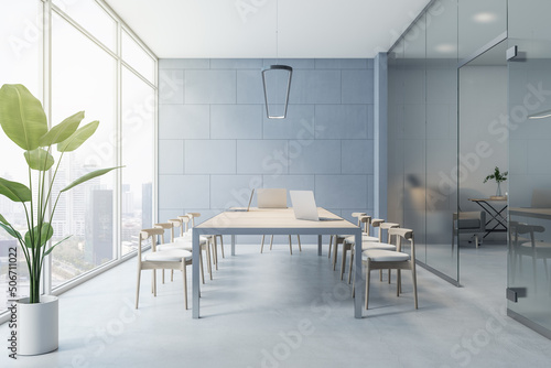 Sunny light spacious conference room with wooden furniture, grey wall, concrete floor and city view from big window. 3D rendering