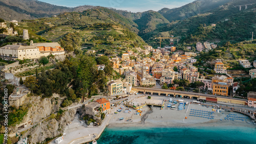 Aerial view of Monterosso and landscape of Cinque Terre,Italy.UNESCO Heritage Site.Picturesque colorful coastal village located on hills.Summer holiday,travel background.Italian Riviera.Torre Aurora