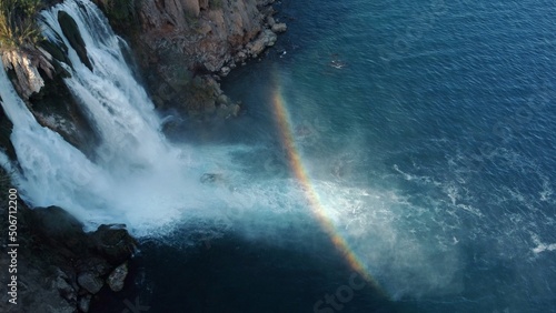 Top aerial view on a waterfall falling from a cliff