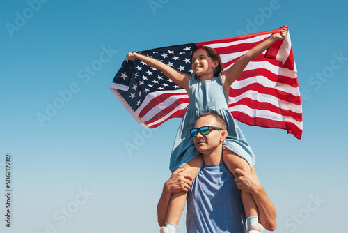 Happy family father and child with usa flag enjoy nature on sky background.