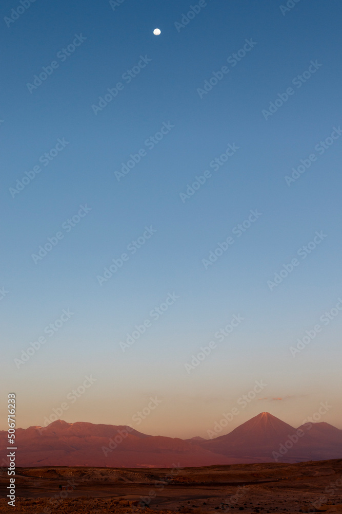 Sunset at the Moon Valley (Valle de la Luna) with the Licancabur volcano and the moon in the background, Atacama, Chile, South America