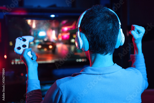 Canvas-taulu Boy in headphones plays a video game on the big TV screen