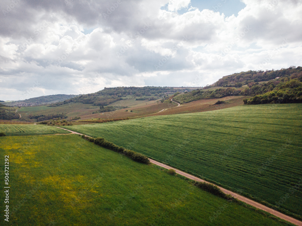 Naklejka premium Vue aérienne d'une route de campagne. Un paysage de campagne. Des collines, des champs, un plateau et une vallée.